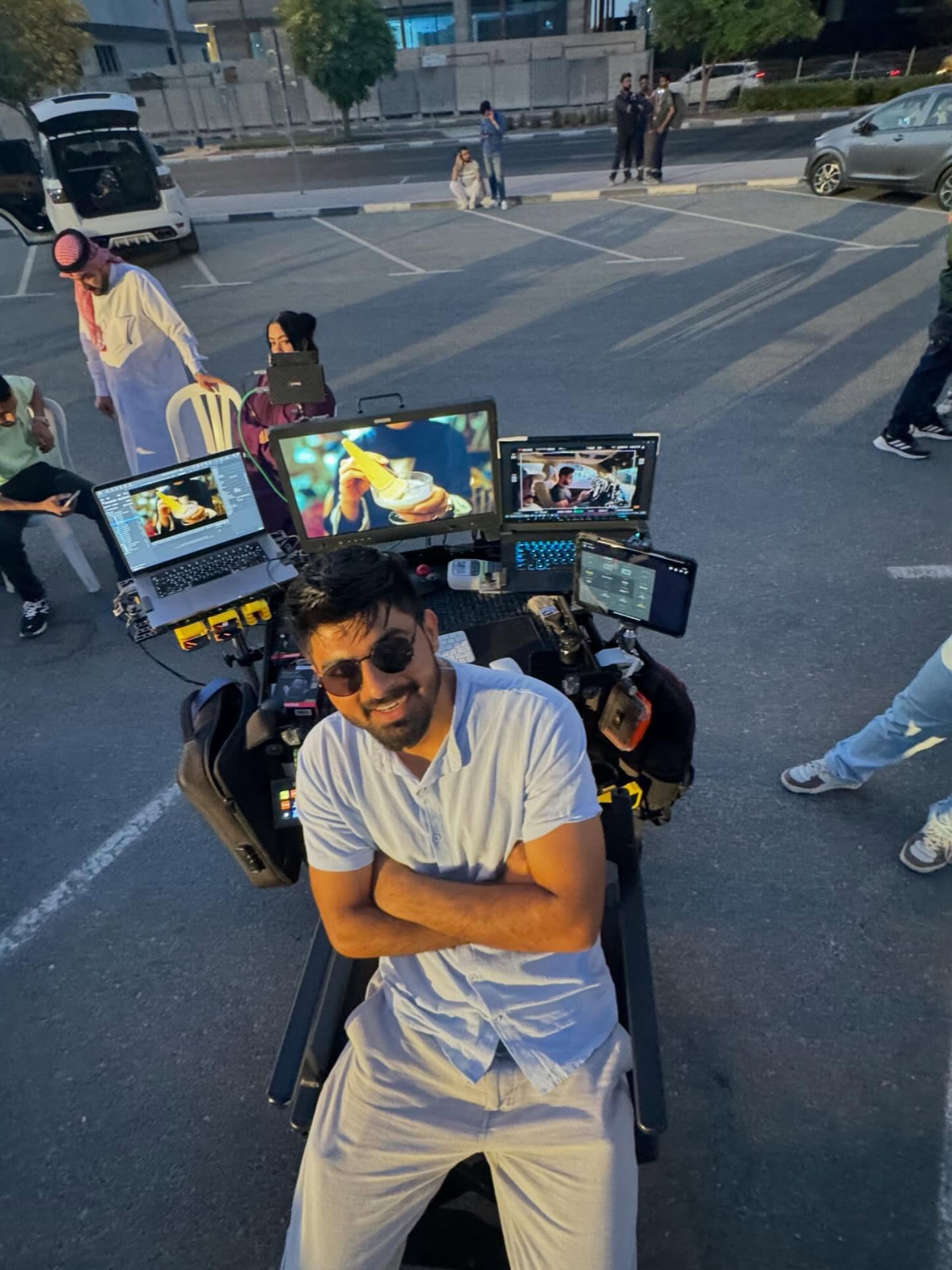 Umair with arms crossed in front of his DIT cart and monitors